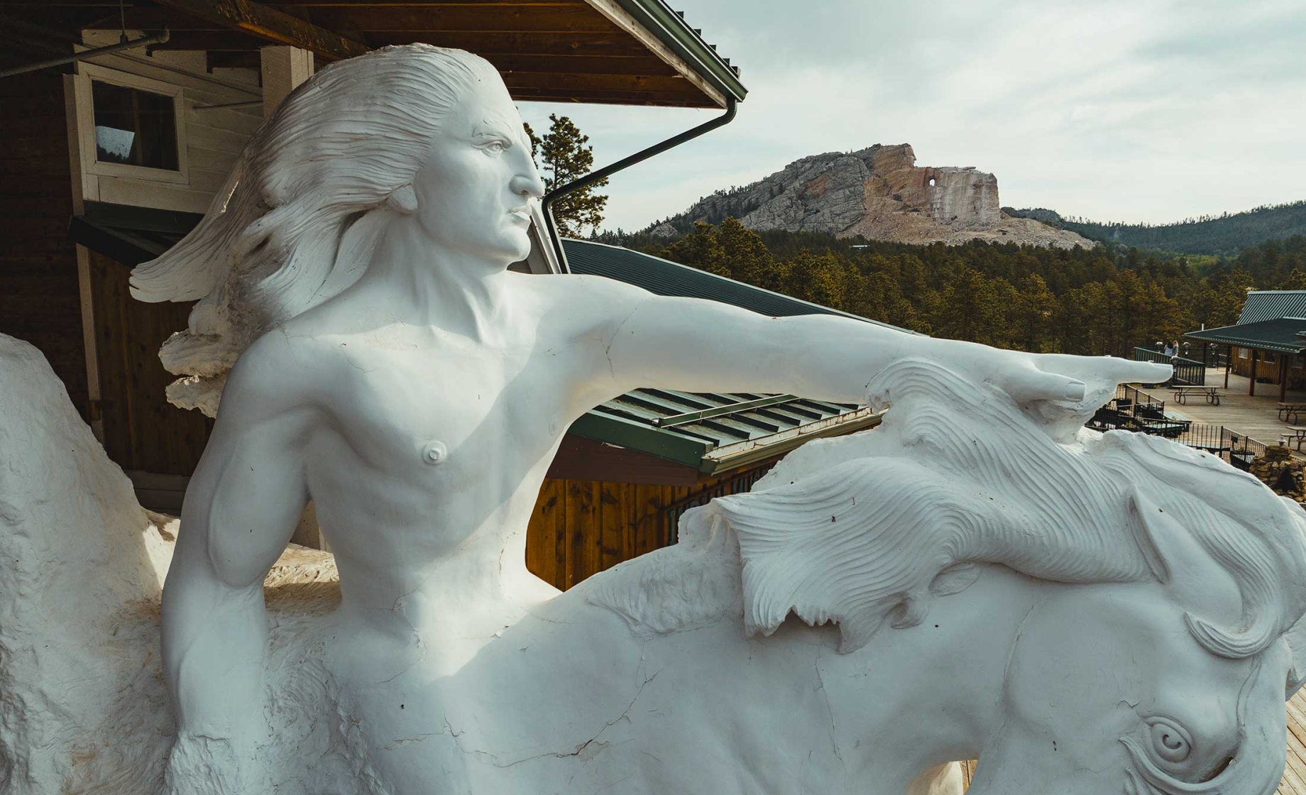A distant view of Crazy Horse Memorial with a smaller model of the sculpture in the foreground. Crazy Horse, South Dakota.